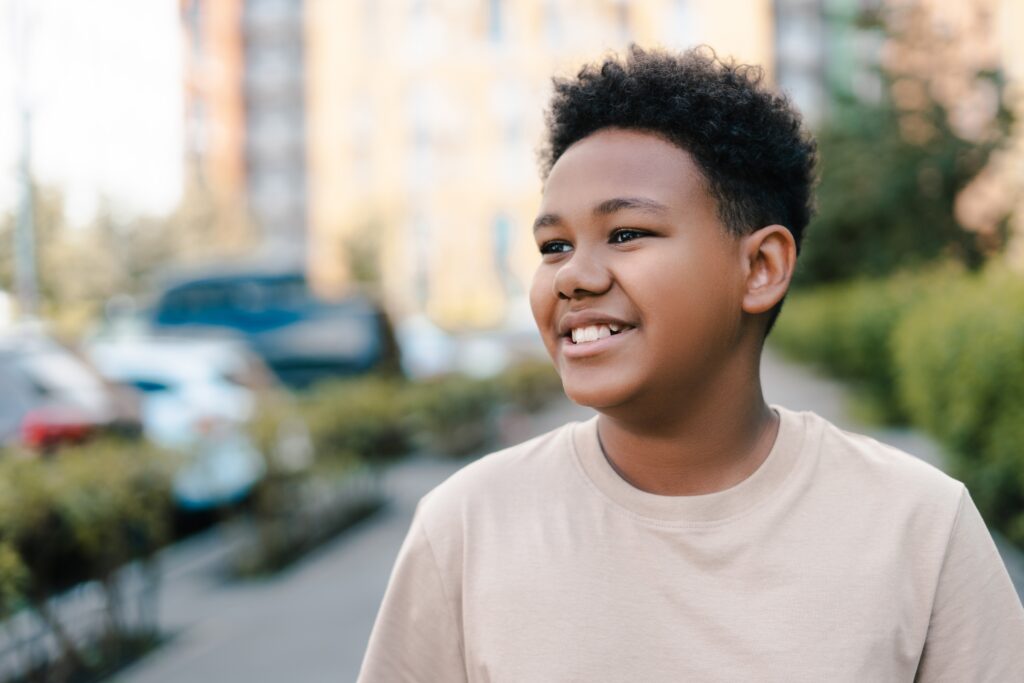 Young black boy smiling outside